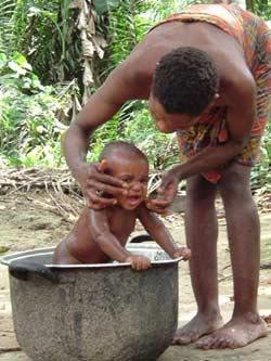 Jeune mère Pygmée baignant son bébé